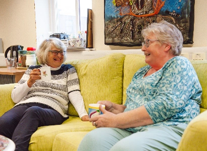 two women sitting on a sofa talking